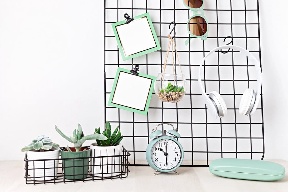 a hanging board with headphones, sunglasses and picture frames, sitting on a desk