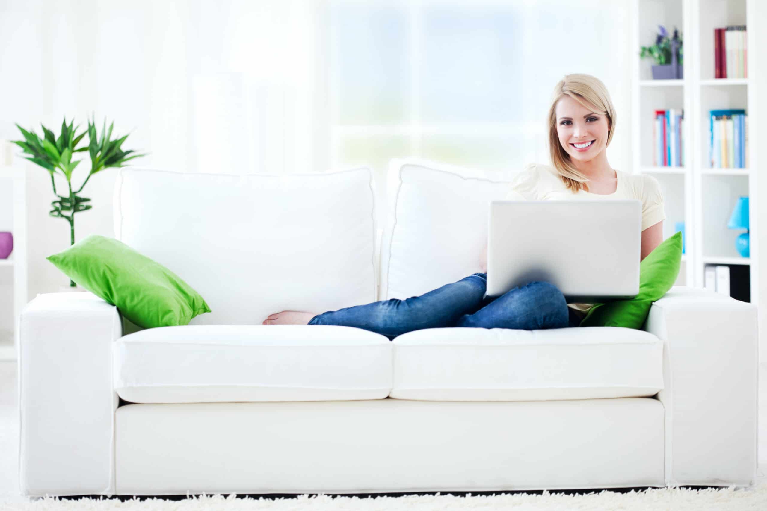 woman on a couch on a computer in a living room