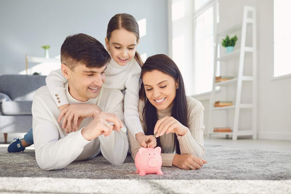 Happy family saves money in a piggy bank pig. Money finance saving concept.