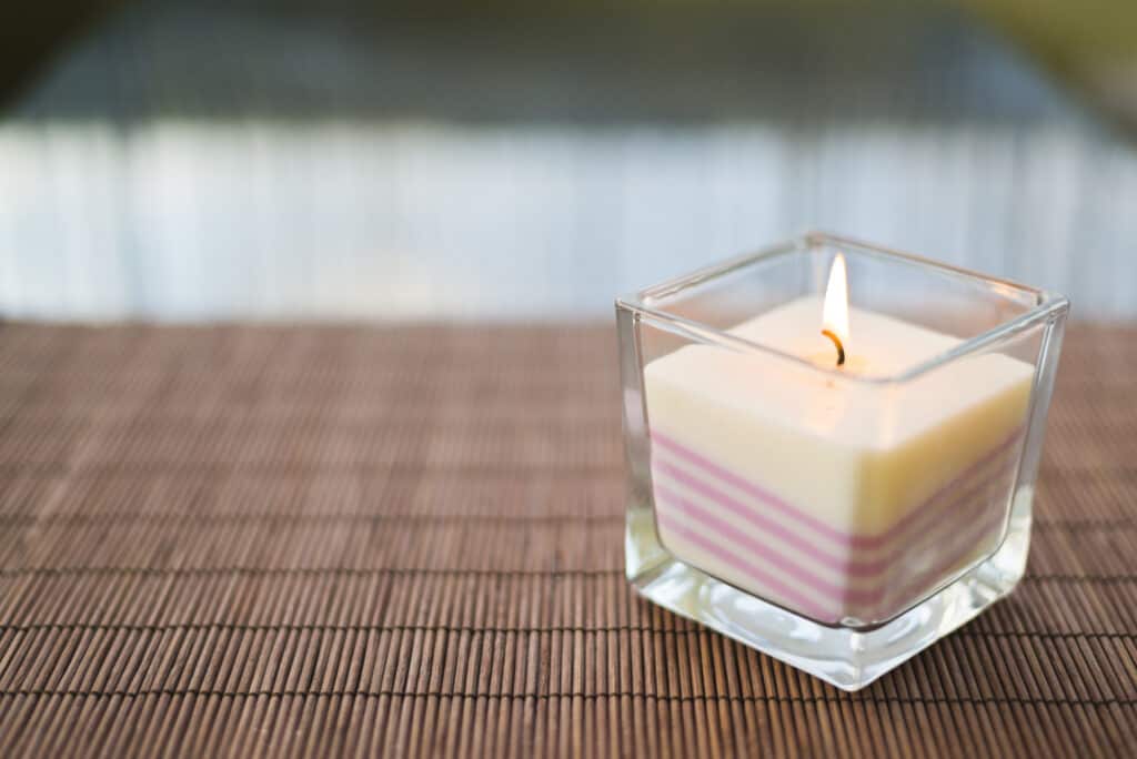 Pink burning candle on table copyspace composition background