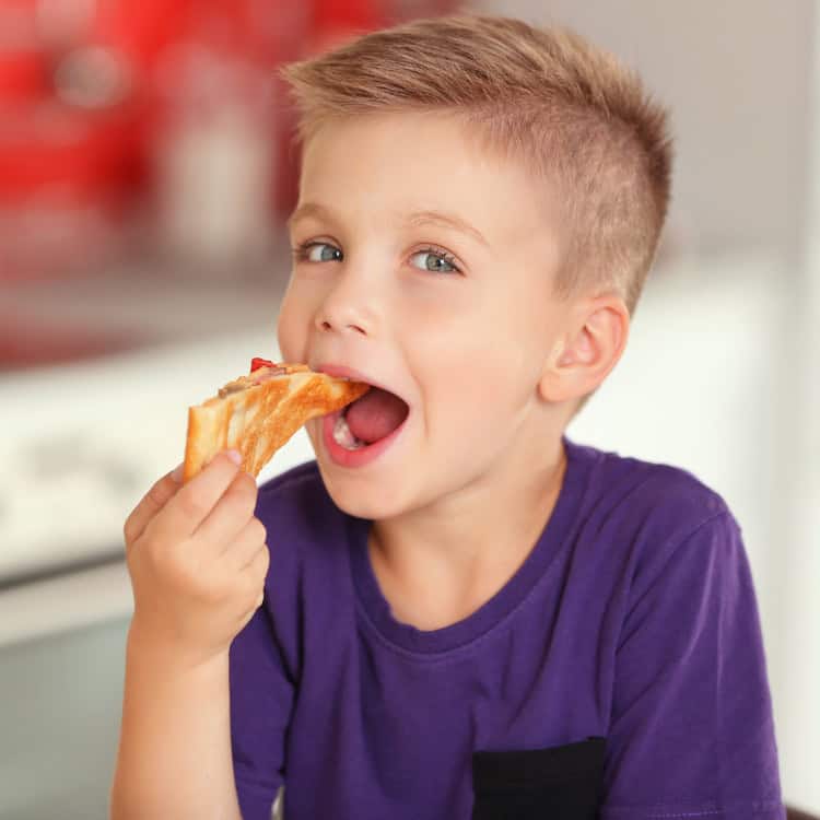little boy eating a snack